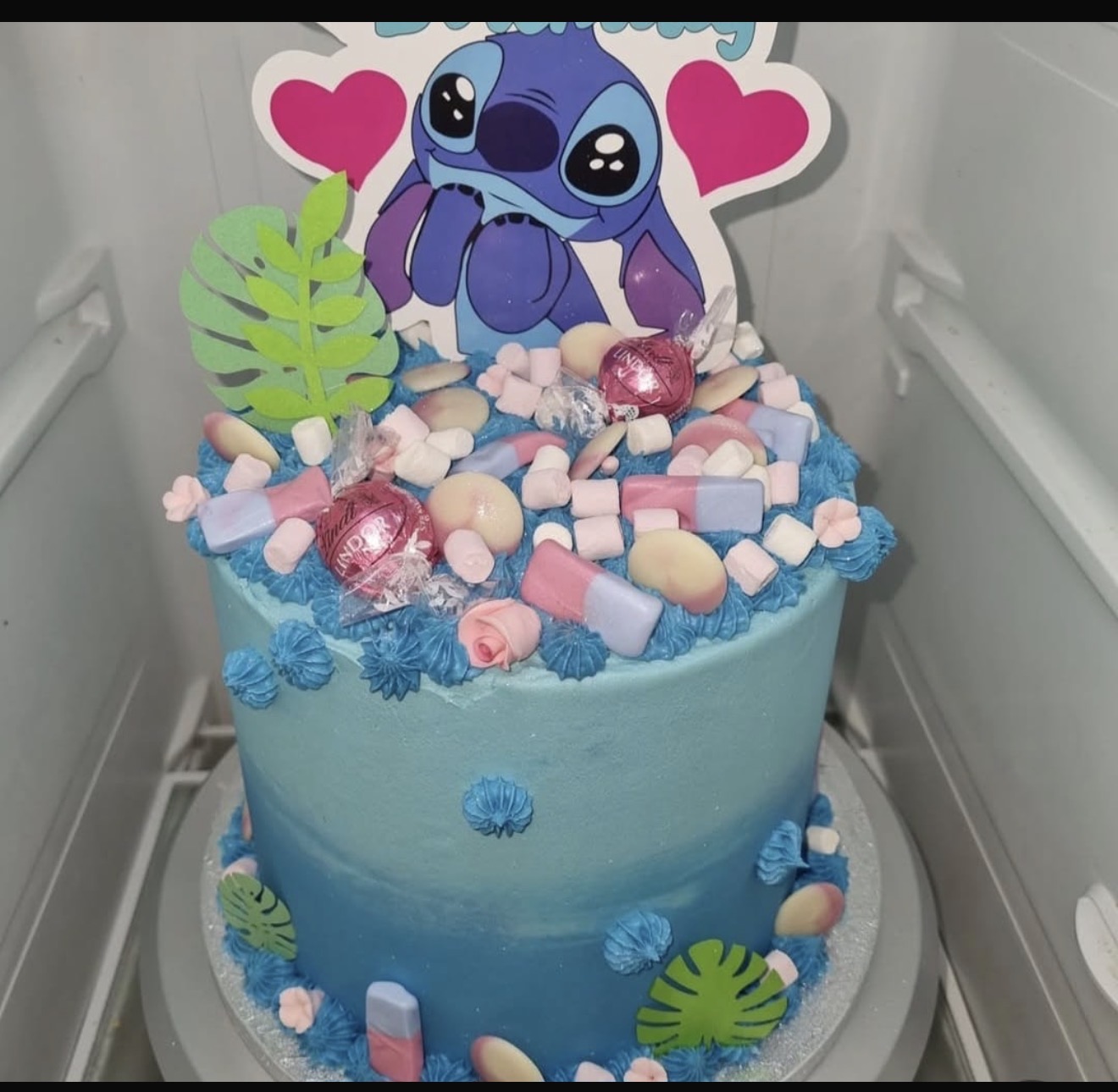 Blue themed celebration cake with colourful decorations