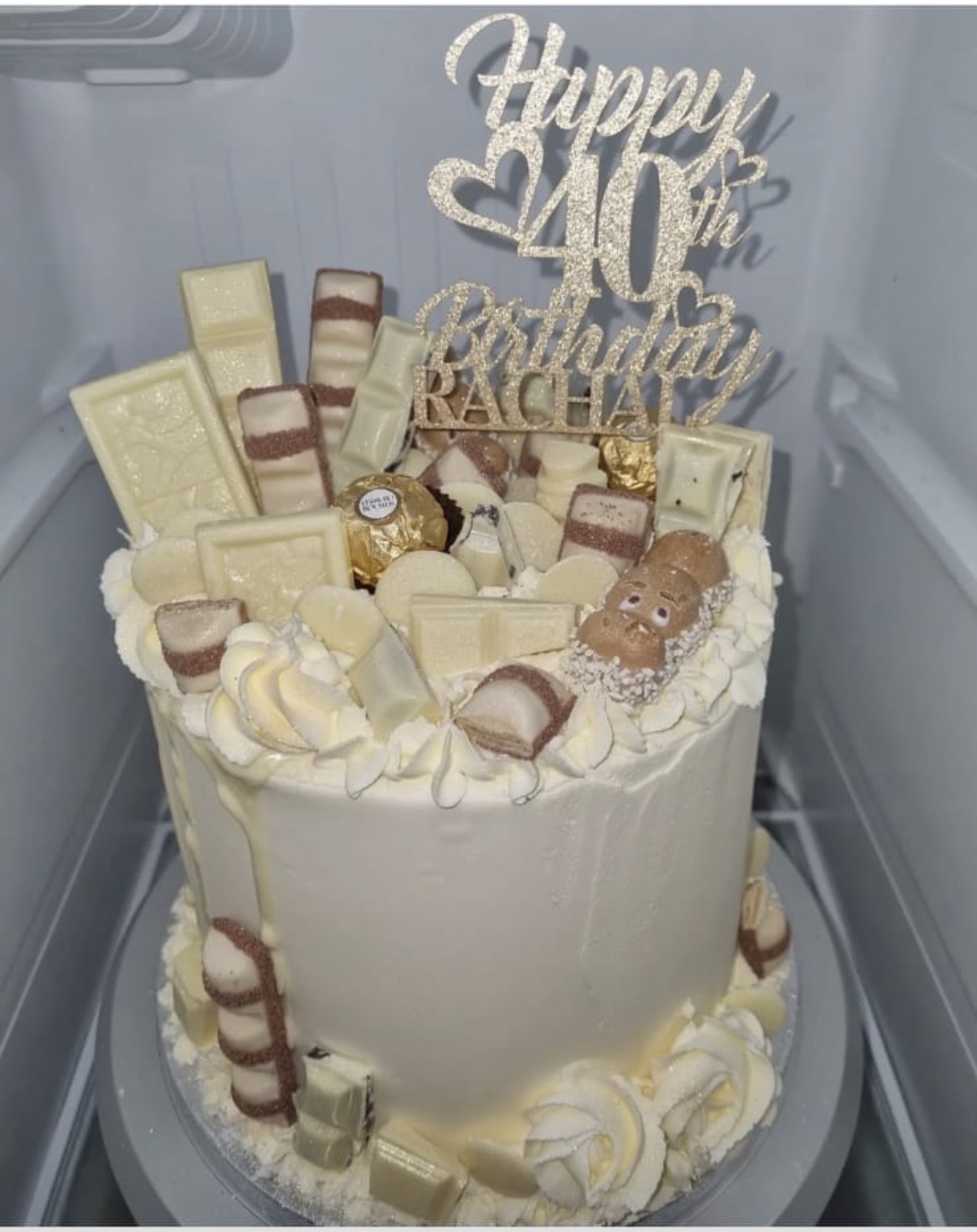 White 40th birthday cake with chocolate decorations and a birthday topper