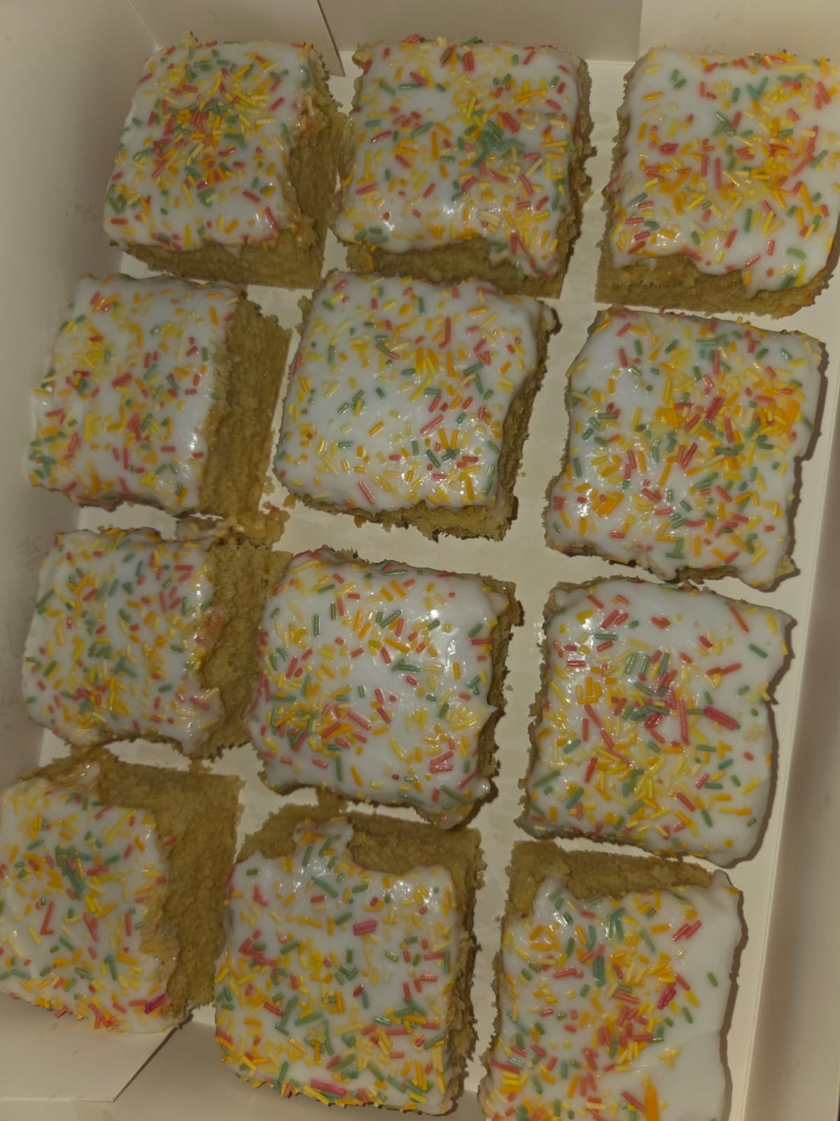 Old School Cake squares with icing and colourful sprinkles